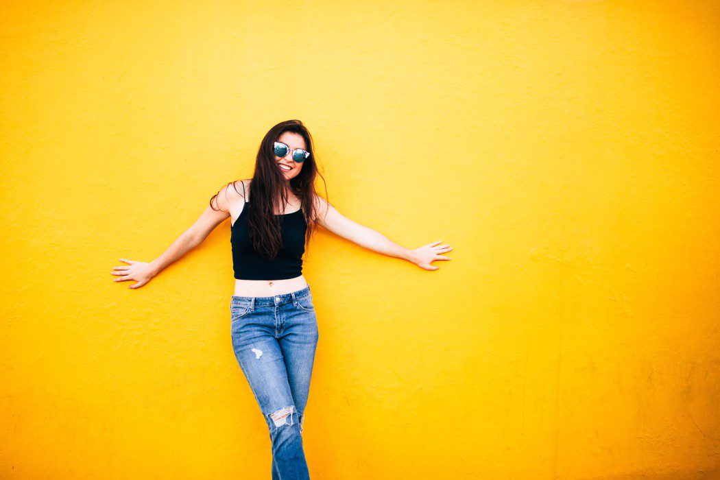 woman standing against yellow wall