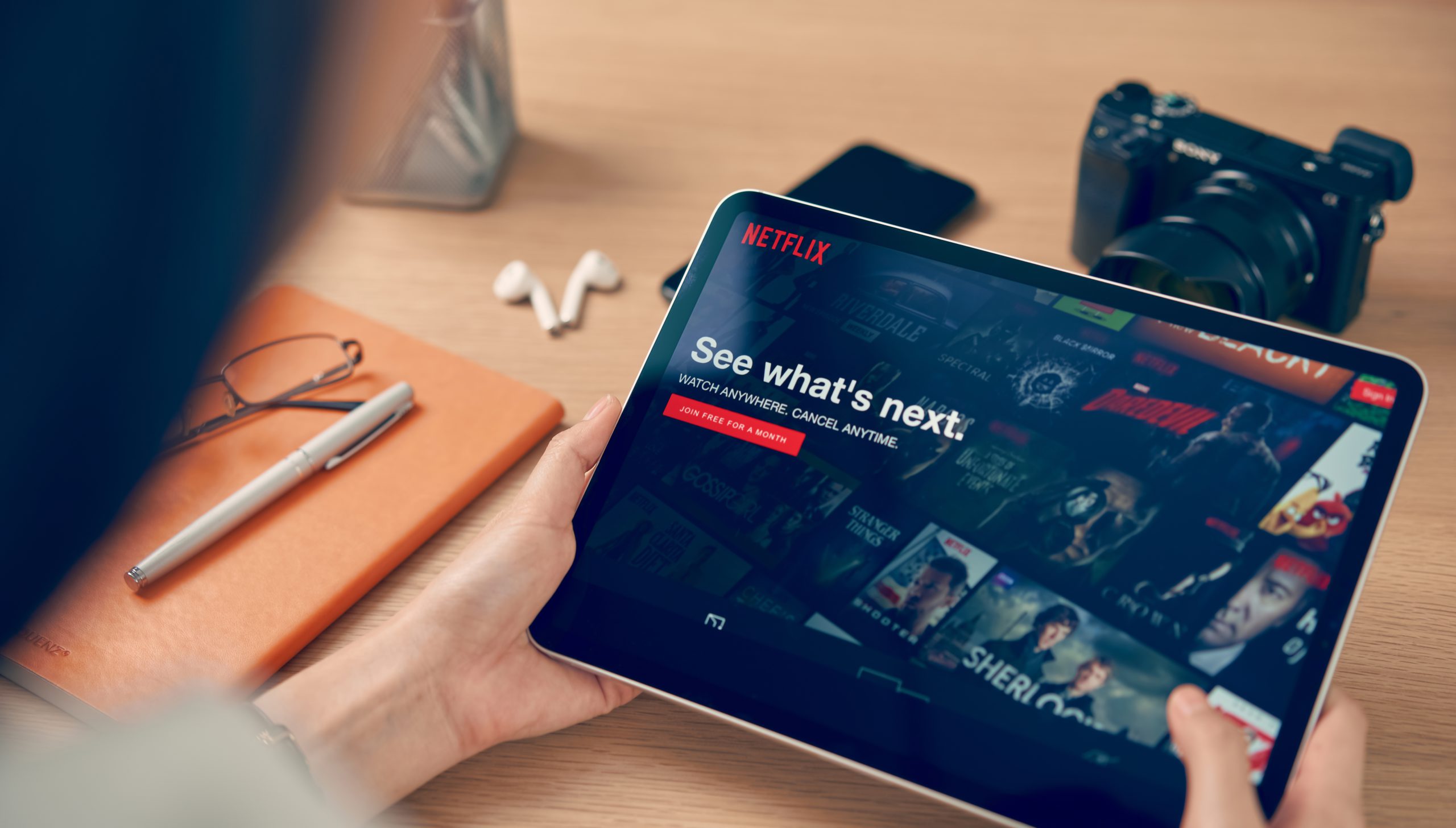 women use Netflix app on iPad Pro screen. Netflix is an international leading subscription service for watching TV episodes and movies